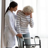 elderly woman uses walker after injury 