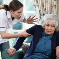 healthcare worker mistreating elderly woman