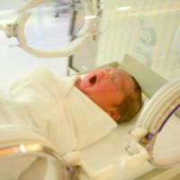 newborn baby yawning in incubator