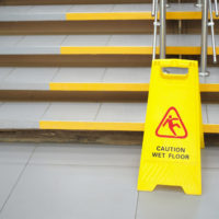 a wet floor sign at the bottom of a flight of stairs