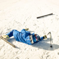 skier lying in snow after ski accident