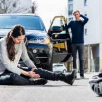 woman sits on ground after bicycle accident